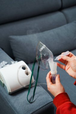 Evde kullanılmadan önce kompresör nebulizörü hazırlama işlemi. Solunum tedavisi için damlayan tıbbi çözüm