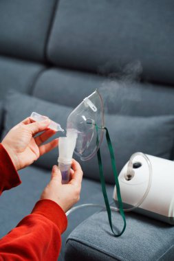 Solunum tedavisi için tıbbi çözelti damlatıyor. Evde kullanılmadan önce kompresör nebulizer hazırlama süreci