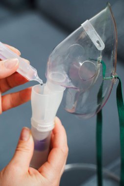 Solunum tedavisi için tıbbi çözelti damlatıyor. Evde kullanılmadan önce kompresör nebulizer hazırlama süreci