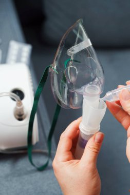 Evde kullanılmadan önce kompresör nebulizörü hazırlama işlemi. Solunum tedavisi için damlayan tıbbi çözüm