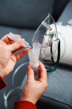 Solunum tedavisi için tıbbi çözelti damlatıyor. Evde kullanılmadan önce kompresör nebulizer hazırlama süreci