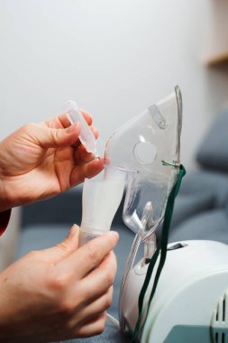 Evde kullanılmadan önce kompresör nebulizörü hazırlama işlemi. Solunum tedavisi için damlayan tıbbi çözüm