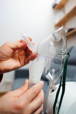 Evde kullanılmadan önce kompresör nebulizörü hazırlama işlemi. Solunum tedavisi için damlayan tıbbi çözüm