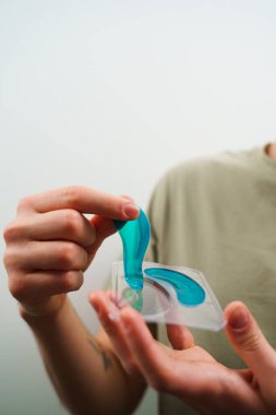 Erkek ellerinin elinde mavi bir kolajen pedi var. Cilt bakımı için yaşlanmayı önleyici nemlendirici göz maskesi