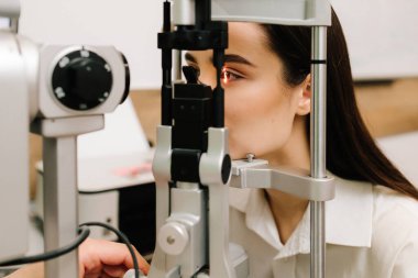 Kız göz muayenesi için göz doktorunu ziyaret ediyor. Göz ve kornea kontrolü için kesik lamba ile oftalmoloji prosedürü