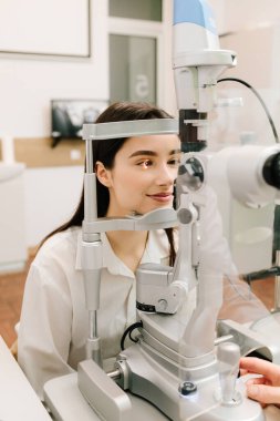 Göz farı ve kornea teşhisi, göz hekimliği kliniğinde. Kesik lambanın gözündeki ışık incelenmek için gözleri ve kızın korneası için.