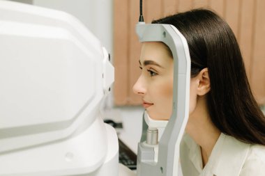 Göz arkası görüntülerini oluşturmak için optik eşkenar tomografi tomografisi. Optik tutarlılık tomografisi kullanan hastaların gözleri inceleniyor. Oftalmolog kız hastaların kornealarını tarıyor.