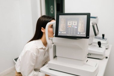 Gelişmiş optik eşkenar tomografi cihazları kullanılarak OKT göz muayenesine tabi tutuluyor. Yüksek çözünürlüklü ekranda göz hastalıklarının erken teşhisine yardımcı olan retina taramaları görülüyor.