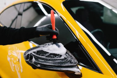 Arabanın aynasına sabunlu bir solüsyon sürme prosedürünü fırça kullanarak detaylandırıyorum. Oto yıkamada çok titiz bir araba.