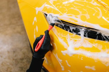 Farları köpük ve yumuşak fırçayla yıkama prosedürü. Araba yıkamada temizlik fırça ve köpükle yapılır.