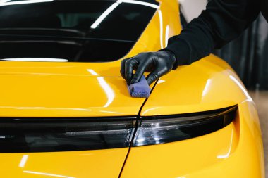Arabayı çiziklerden korumak için nano seramik koruyucu palto kullanıyorum. Otomobil servisinin detaylandırılmasında sünger yakın çekim kullanılarak seramik katman uygulanması işlemi