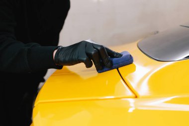 Arabayı çiziklerden korumak için nano seramik koruyucu palto kullanıyorum. Otomobil servisinin detaylandırılmasında sünger yakın çekim kullanılarak seramik katman uygulanması işlemi