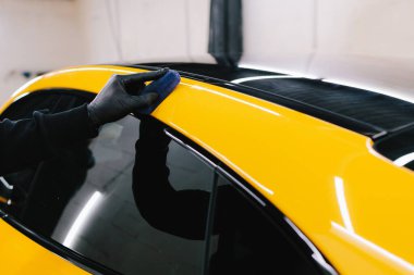 Seramik kaplama işlemi, servisteki detaylı oturum sırasında korunmak için spor araba yüzeyine uygulanır. Araba servisinde seramik cilalama ayrıntıları