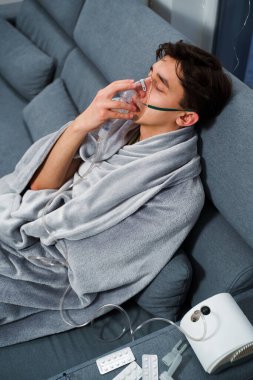 Zatürree tedavisi için nebulizör yoluyla nefes alan hasta. Ev virüsü tedavileri için nebulizatörle nefes almak