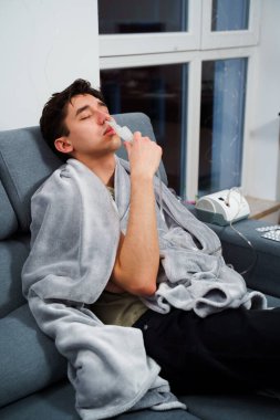 Astım krizi geçiren genç bir adam solunum cihazıyla nefes alıyor. Evde nebulizörle burun solumuş.