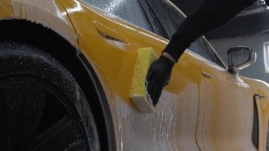 İdeal oto yıkama ve araba bakımı videosu. Parlak ve lekesiz bir dış görünüş için spor arabayı sünger ve sabunla yıkamak.