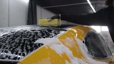 Parlak, lekesiz bir dış görünüş için spor arabayı sünger ve sabunla yıkamak. İdeal oto temizleme ve araba bakımı 4k video