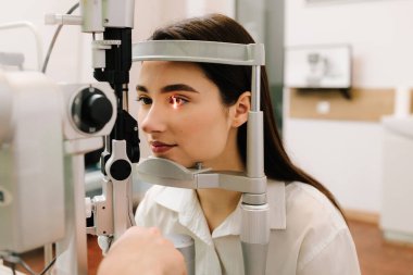 Kız göz muayenesi için göz doktorunu ziyaret ediyor. Göz ve kornea kontrolü için kesik lamba ile oftalmoloji prosedürü