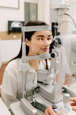 Göz farı ve kornea teşhisi, göz hekimliği kliniğinde. Kesik lambanın gözündeki ışık incelenmek için gözleri ve kızın korneası için.