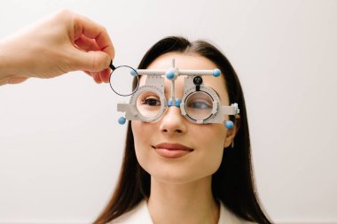 Doğru reçeteli lensleri belirlemek için deneme çerçevesi gözlüğü. Göz muayenesi için göz doktorunun deneme çerçevesi gözlüğü takıyor.