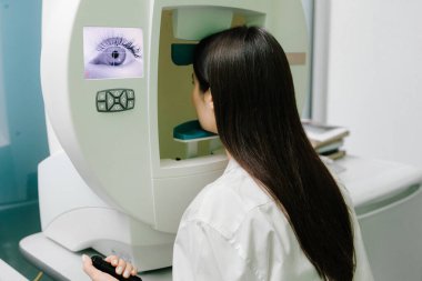 Yan ve çevresel görüş dahil olmak üzere tüm görüş alanlarını ölçmek için perimetri görsel alan testi. Göz perimetri testi, göz hastalıkları kliniğindeki kadının glokom belirtilerini gösteriyor.