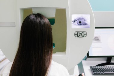 Yan ve çevresel görüş dahil olmak üzere tüm görüş alanlarını ölçmek için perimetri görsel alan testi. Göz perimetri testi, göz hastalıkları kliniğindeki kadının glokom belirtilerini gösteriyor.