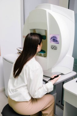 Göz perimetri testi, göz hastalıkları kliniğindeki kadının glokom belirtilerini gösteriyor. Kenar ya da çevresel görüş dahil olmak üzere tüm görüş alanlarını ölçmek için perimetri görsel alan testi