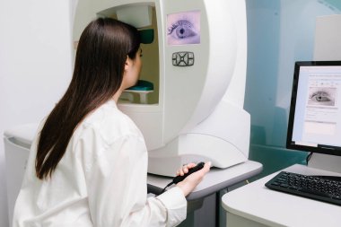 Bir göz hekimliği kliniğindeki kadınlarda glokom belirtileri için perimetri testi, çevresel görme de dahil olmak üzere tam görme yeteneğini ölçer.