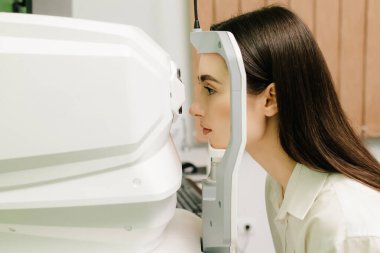 Göz arkası görüntülerini oluşturmak için optik eşkenar tomografi tomografisi. Optik tutarlılık tomografisi kullanan hastaların gözleri inceleniyor. Oftalmolog kız hastaların kornealarını tarıyor.