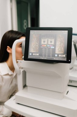 Gelişmiş optik eşkenar tomografi cihazları kullanılarak OKT göz muayenesine tabi tutuluyor. Yüksek çözünürlüklü ekranda göz hastalıklarının erken teşhisine yardımcı olan retina taramaları görülüyor.