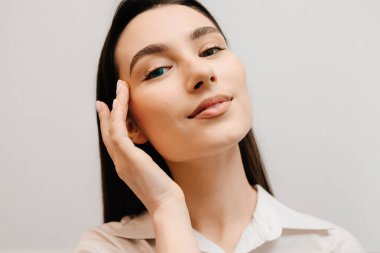 Gözleri farklı renklerde, heterokromisi olan mavi kontakt lensli bir kız. Beyaz arka planda renkli kontak lensli kız gözlerinde renk bozukluğu.