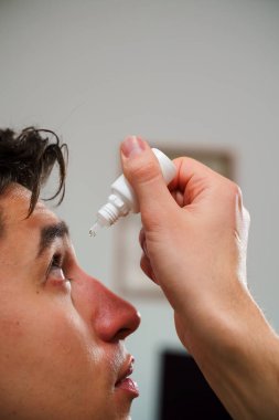 Adamın gözü tahriş sorunu yüzünden damlıyor. Evde göz damlası kullanılıyor.