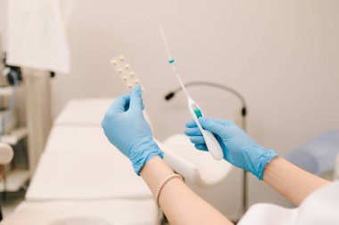 Uzun vadeli doğum kontrolü için tıbbi doğum kontrolü. Jinekolog ellerinde doğum kontrol hapı ve IUD cihazı tutuyor.