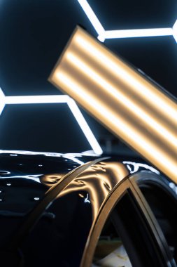 Araç paneli PDR aydınlatmasının altında birden fazla ezik olduğunu gösteriyor. Kusurları ortaya çıkarmak için acısız bir çukur onarımında kullanılmış. PDR ışıkları, hasar tespiti ve değerlendirmesi için