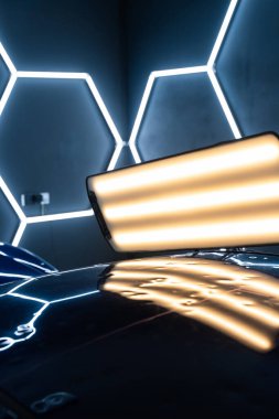 PDR ışıkları, doğru göçüğü tespit etme ve değerlendirme için hasar veriyor. Araç paneli PDR aydınlatmasının altında çoklu göçükler gösteriyor. Kusurları ortaya çıkarmak için acısız göçüklerde kullanılır.