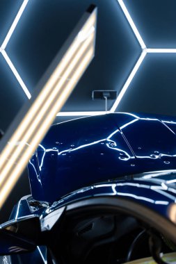 PDR ışıkları, doğru göçüğü tespit etme ve değerlendirme için hasar veriyor. Araç paneli PDR aydınlatmasının altında çoklu göçükler gösteriyor. Kusurları ortaya çıkarmak için acısız göçüklerde kullanılır.