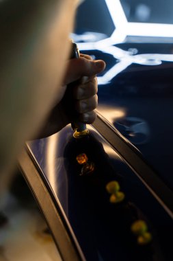 Ağrısız araba göçüğü teknisyeni, araba gövdesi panellerini onarmak için tutkal şeritlerine sürgülü çekiç kullanıyor. PDR Ayrıntılı yansıma çizgileri kusursuz yüzey restorasyonu için hassas çekme kılavuzu