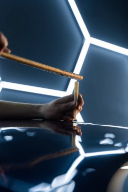 PDR gelişmiş tekniği acısız çukur temizleme onarımı tamamlanır. Kesinlik tıkırdatma aracı parlak altıgen LED ışıklar altında ağrısız çukur onarım sırasında araba yüzeyini rafine eder