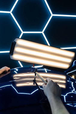 PDR teknisyeni, çarpma aletini ve çekiç kombinasyonunu dolu izlerini düzeltmek için kullanır. Odaklanmış vuruşlar boyaya zarar vermeden metali yeniden hizaladı. Devrilmiş bir aletle kontrol edilen musluklar dolu ile bükülmüş metali yeniden şekillendirir