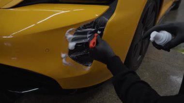 4K video 'da araba yıkama prosedürü. Temizleyici fırça kullanarak sabun köpüğü ile hava sistemini yıkar