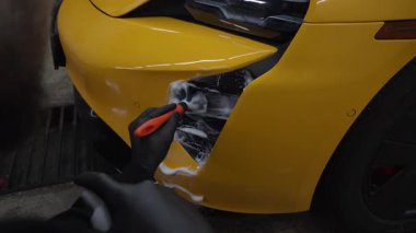 4K video 'da araba yıkama prosedürü. Temizleyici fırça kullanarak sabun köpüğü ile hava sistemini yıkar