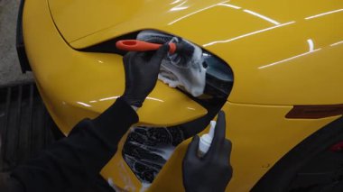 Araba farları köpük ve yumuşak fırça ile temizleniyor. 4K video. Spor araba farlarını temizleme işlemi. Sabun köpüğü ve fırçayla yıkayın.