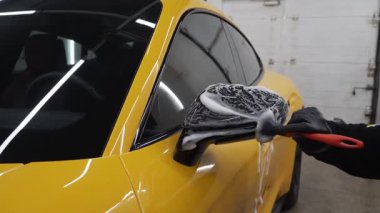 4k fırça videosu kullanarak arabalara sabunlu bir solüsyon uygulamak. Oto yıkamada çok titiz bir araba.