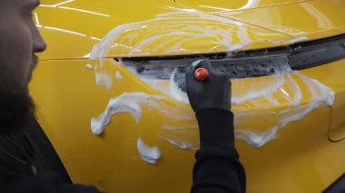 Farları köpüklü ve fırçalı 4K video ile yıkama prosedürü. Araba yıkamada temizlik fırça ve köpükle yapılır.