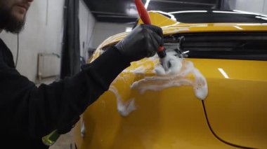 4K video 'da temizlik fırça ve köpükle yapılıyor. Farları köpük ve yumuşak fırçayla yıkama prosedürü