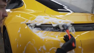 4K video 'da temizlik fırça ve köpükle yapılıyor. Farları köpük ve yumuşak fırçayla yıkama prosedürü