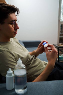 Adamın elinde astigmat tedavisi için lens kutusu var. Optik kontak lenslerle görme düzeltmesi