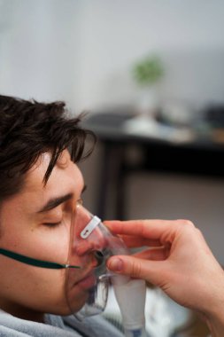 Zatürree tedavisi için nebulizör yoluyla nefes alan hasta. Ev virüsü tedavileri için nebulizatörle nefes almak