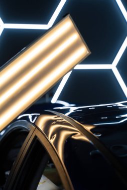 PDR ışıkları, doğru göçüğü tespit etme ve değerlendirme için hasar veriyor. Araç paneli PDR aydınlatmasının altında çoklu göçükler gösteriyor. Kusurları ortaya çıkarmak için acısız göçüklerde kullanılır.