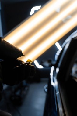 Hassas ve acısız bir tamir seansı sırasında araba yüzeyine yapıştırıcı sürmüş. Yüksek yansıma aydınlatması kusursuz araba göçüğü temizleme için görünürlüğü artırır